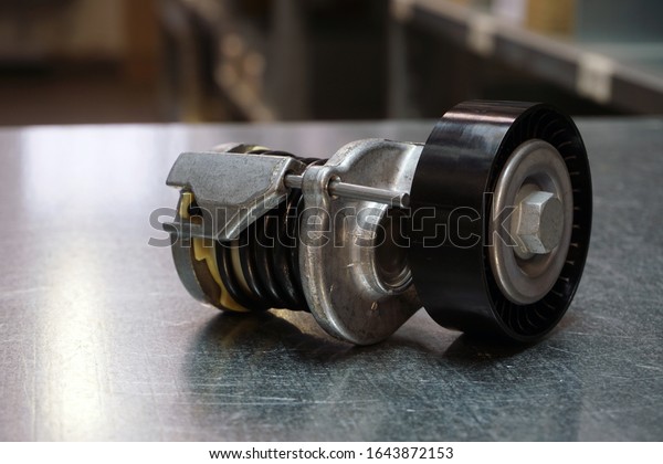 Engine parts of a modern car.\
Tension roller of a drive belt . New original quality spare parts.\
Trade in spare parts. Service and repair of a modern car.\
