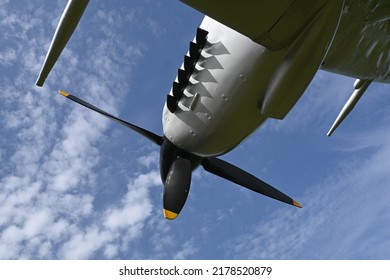 Engine And Propeller Of WW2 Fighter Plane Seen From Below Against Blue Sky.