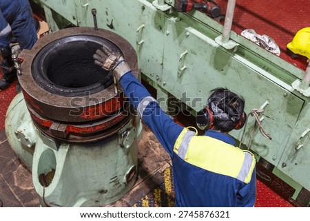 Engine room crew member working on propulsion system valve components during overhaul procedure.