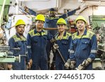Engine room crew members posing in ship maintenance workshop.