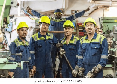 Engine room crew members posing in ship maintenance workshop.