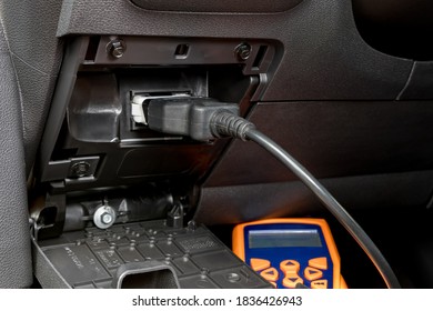 Engine scan tool plugged into car computer connection. Concept of automotive repair, maintenance, service and vehicle check engine light.