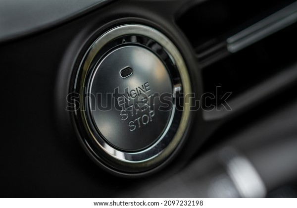 Engine start button. Close up engine\
car start stop button. Modern car interior\
details.