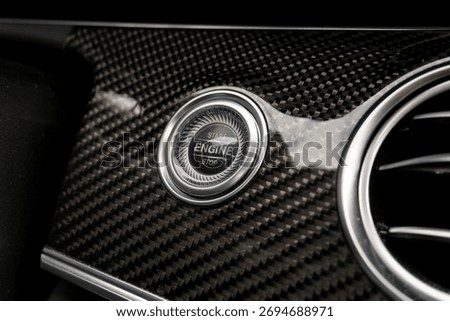 Engine Start Stop Button on a carbon fiber trimmed dashboard in an exclusive luxury car