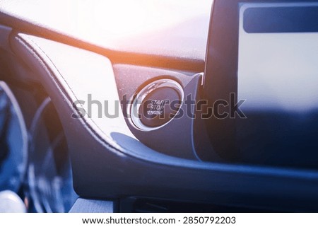 Engine start stop push button in modern car interior. Dashboard control and blank infotainment screen. Keyless ignition system. Automotive technology and modern driving background.