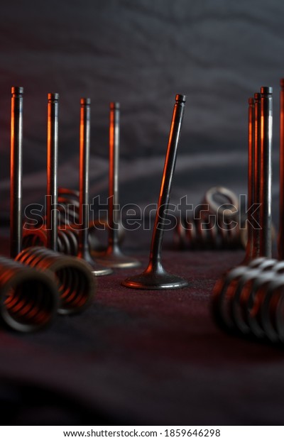 engine valve with fault and set of unbroken valves\
on table of repair shop