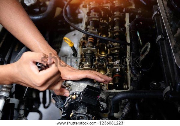Engine Valve with Mechanic fixing, Closeup hands
working with tool.