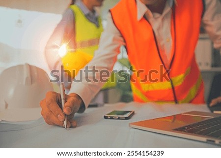 engineer or architect planning with technology concept, construction worker draw and designer on blue print and watching on laptop