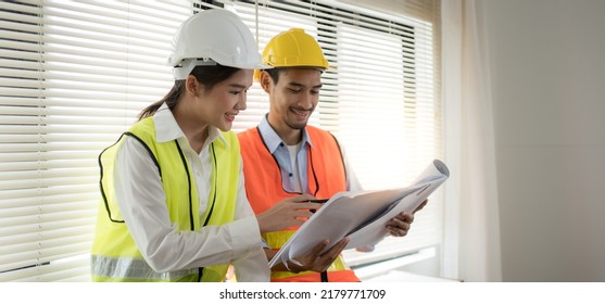 Engineer And Architect Smiling Discuss, Review The Construction Drawings, Blueprints, Plan The Construction Work And Renovate Project According To The Plan.