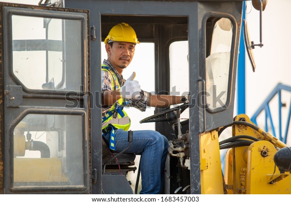 Engineer or architect with white helmet driving\
Loader Truck at construction site,Engineering Construction Car\
Vehicle at the work\
area.