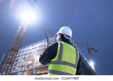 Engineer Architect Worker On Construction Site At Night Shift Communicating With Two Way Radio