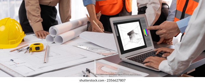 Engineer and architect working together brainstorming and designing blueprint using laptop working with architectural software for precise digital interior or structure design. Insight - Powered by Shutterstock