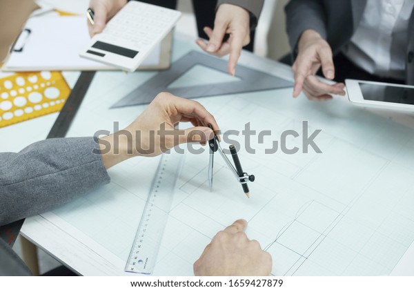 Engineer Architects office team working and\
discussing with\
blueprint