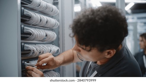 IT Engineer Assembles Custom Ethernet Patch Cord by Crimping RJ45 Connector Onto Twisted Pair Cable, Verifying Pinout and Maintaining Organized Structured Cabling For Reliable Network Connectivity.