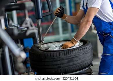 engineer  balancing  car wheel on balancer in workshop - Powered by Shutterstock