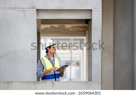 Engineer builder. Foreman work in construction site. Construction site manager standing wearing safety vest and helmet,using his tablet at construction site.