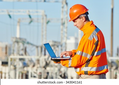 Engineer Builder With Laptop Computer At Construction Site Near Power Plant