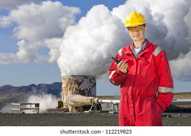 Engineer With Cb Radio Standing Next To The Violently Emitting Tube Of A Geothermal Energy Plant