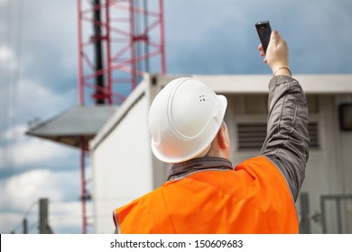 Engineer With The Cell Phone Near To Gsm Tower