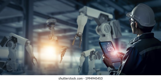 Engineer check and control robotics automatic arms machine in intelligent and smart factory automotive industrial on real time monitoring system software. Digital manufacturing operation. Industry 4.0
