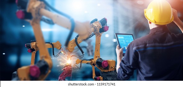 Engineer check   control welding robotics automatic arms machine in intelligent factory automotive industrial and monitoring system software  Digital manufacturing operation  Industry 4 0