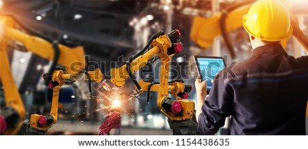 Engineer check and control welding robotics automatic arms machine in intelligent factory automotive industrial with monitoring system software. Digital manufacturing operation. Industry 4.0 Stockfoto © 