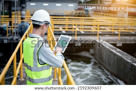 Engineer check water quality in tablet  program for wastewater treatment pond to check the quality after going through the wastewater treatment process in safety industry environment concept,
