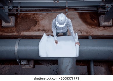 Engineer Checking Blueprint Of Industry Cooling Tower Air Conditioner Is Water Cooling Tower Air Chiller HVAC Of Large Industrial Building To Control Air System ,wearing Mask For Protect Pollution.