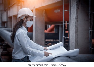 Engineer Checking Blueprint Of Industry Cooling Tower Air Conditioner Is Water Cooling Tower Air Chiller HVAC Of Large Industrial Building To Control Air System ,wearing Mask For Protect Pollution.