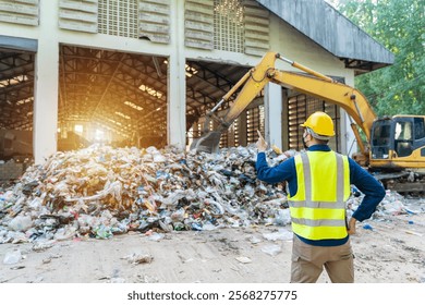 An Engineer checking diagnostics on a laptop while standing next to recycling machinery, ensuring smooth operations in waste separation plant.