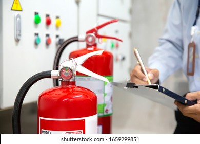 Engineer Are Checking Fire Extinguishers In The Fire Control Room For Safety And Prevention.