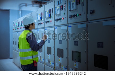 Engineer checking and inspecting at MDB panel .he working with electric switchboard to check range of voltage working in Main Distribution Boards factory.