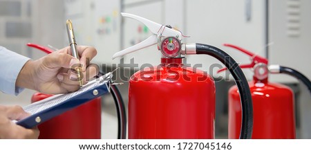 Engineer are checking and inspection a fire extinguishers tank in the fire control room for safety training and fire prevention.