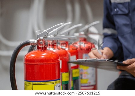 Engineer are checking and inspection a fire extinguishers tank in the fire control room for safety training and fire prevention.