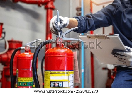 Engineer are checking and inspection a fire extinguishers tank in the fire control room for safety training and fire prevention.