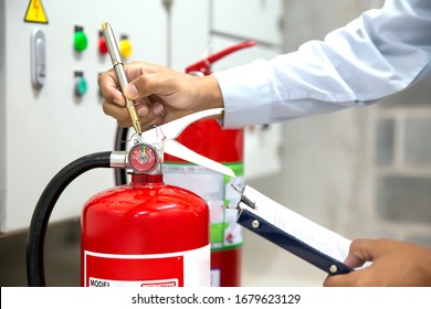 Engineer Are Checking And Inspection A Red Fire Extinguishers In The Fire Control Room For Safety Prevention And Fire Training.