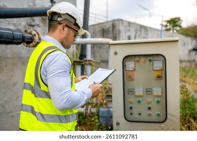 An engineer is checking the operation of an electrical switchboard in a large waterworks