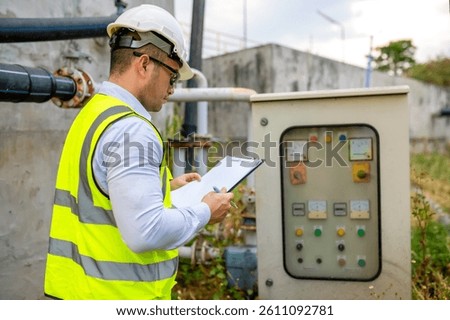 An engineer is checking the operation of an electrical switchboard in a large waterworks