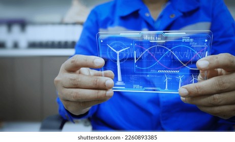 Engineer is checking the power parameters real time status of a wind turbine generator through AI Hologram screen. Artificial intelligence, helps in analyzing and solving energy problems. Green energy