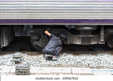 engineer checking train wheel system