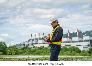 Engineer With A Coal Power Plant In The Background, Thailand.