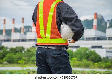 Engineer With A Coal Power Plant In The Background, Thailand.