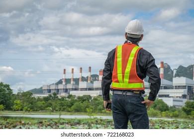 Engineer With A Coal Power Plant In The Background, Thailand.