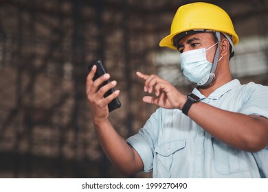 Engineer Company Employee Wearing A Dust Mask And Covid 19 Virus Uses A Smartphone To Control Work.
