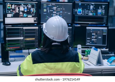Engineer computer worker on High-performance computers with a lot of monitor in large factory,Control the operation of large machines,Write a program to run the robot,Programmer working with serious