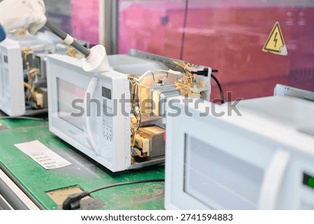 Engineer conducts microwave leakage testing on production line for quality assurance