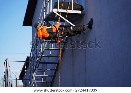 Engineer, construction worker. Man in uniform. Rock climber, arborist. Industrial climber. Working at height. Rescuer, firefighter, dangerous occupation, ropes, carabiners. Industrial climber at work. High-altitude work, dexterous stunt, circus performer, virtuoso, stuntman, dangerous profession. Extreme sportsman                             