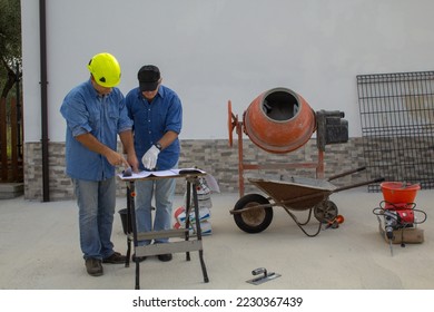 Engineer and construction worker on a construction site consulting building plans. Inspection and building controls with labor inspector.
