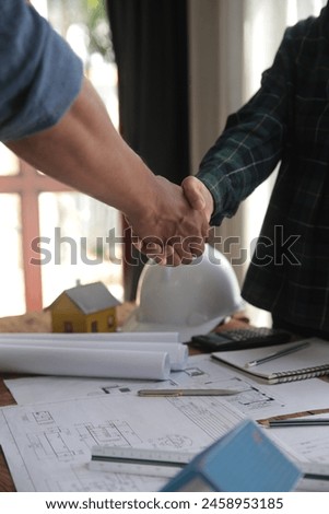 Engineer and contractor join hands after signing contract,They are having a modern building project together. successful cooperation team concept