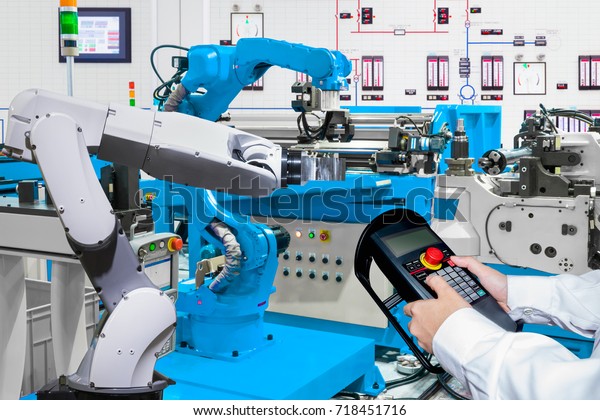 Engineer control automatic robotic hand\
machine tool at industrial\
manufacture